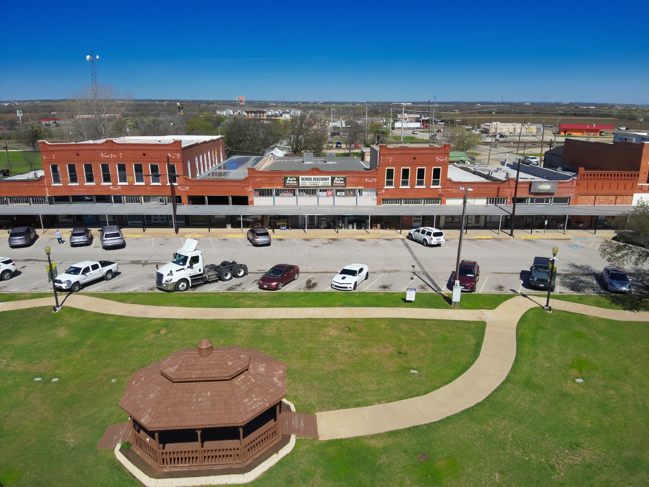 Aerial view of downtown Venus, Texas, showing historic brick storefronts, the downtown square, streets, and the community gazebo.